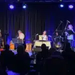 Adelaide Baroque ensemble on stage with santur, strings and percussion under blue lighting