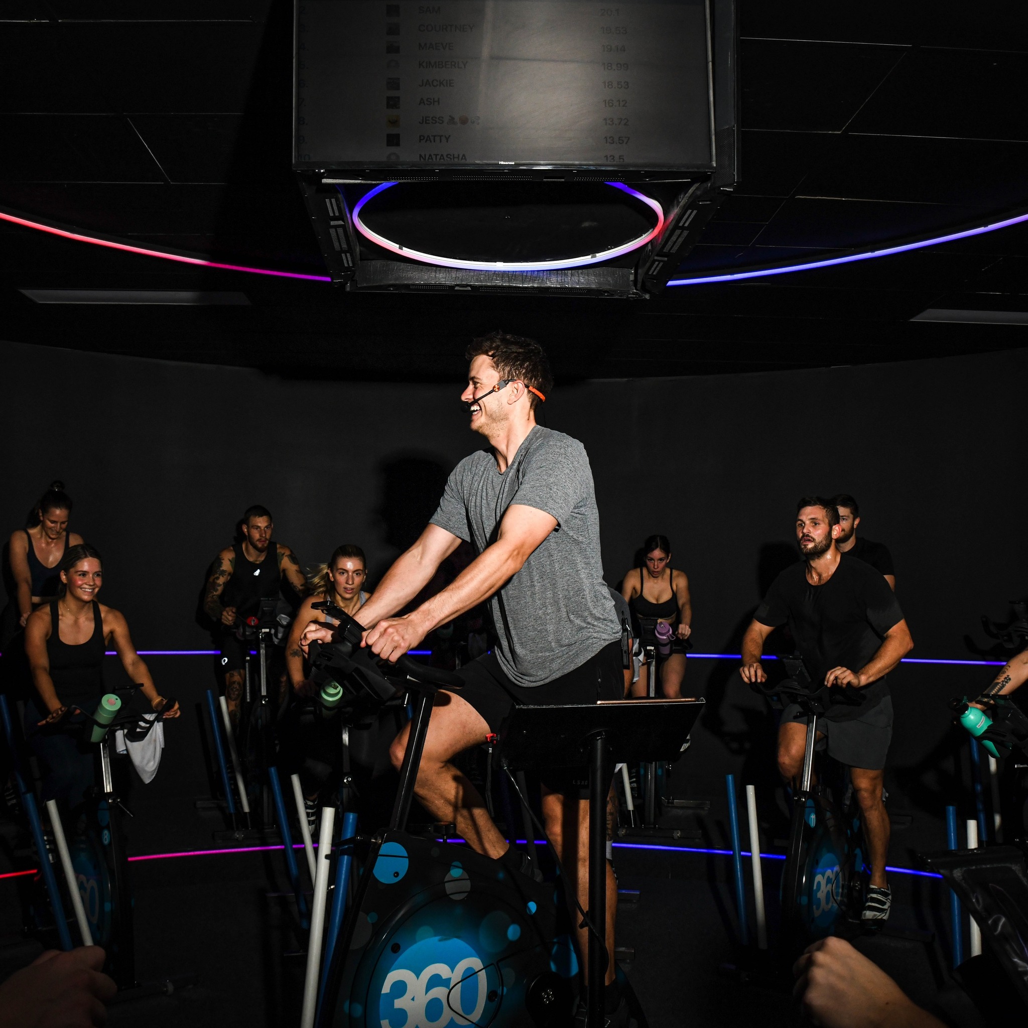 Man and others on stationary bikes at a spin class
