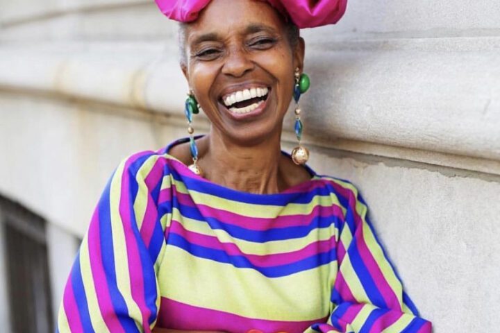 Woman wears colourful clothes as she smiles big