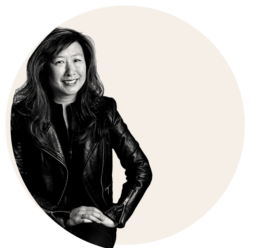 A monochrome portrait of a woman posing with her hand on her knee