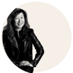 A monochrome portrait of a woman posing with her hand on her knee