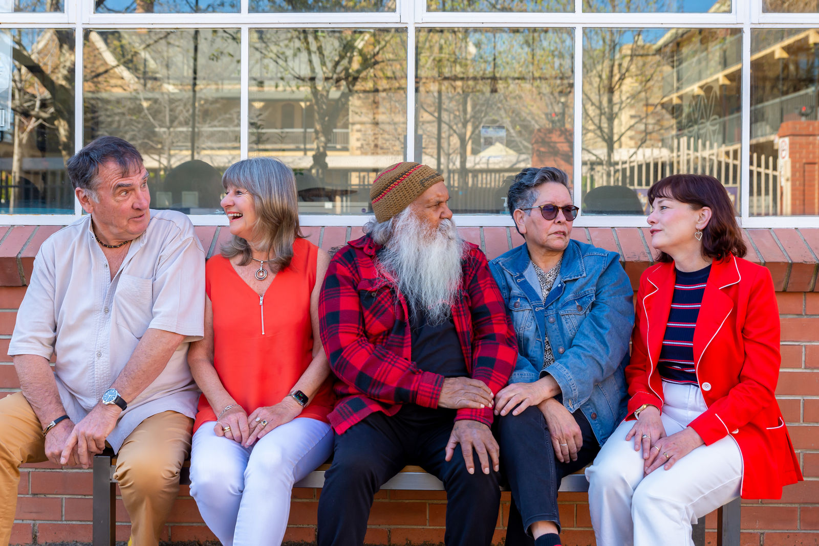 Older adults sit on a bench together