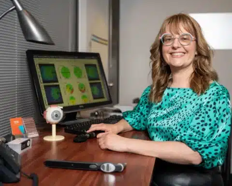 Design Eyewear Optometrist sitting at their desk.