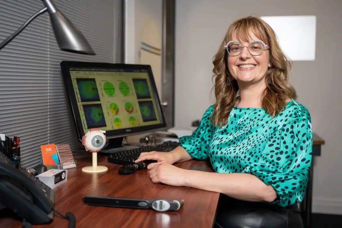 Design Eyewear Optometrist sitting at their desk.