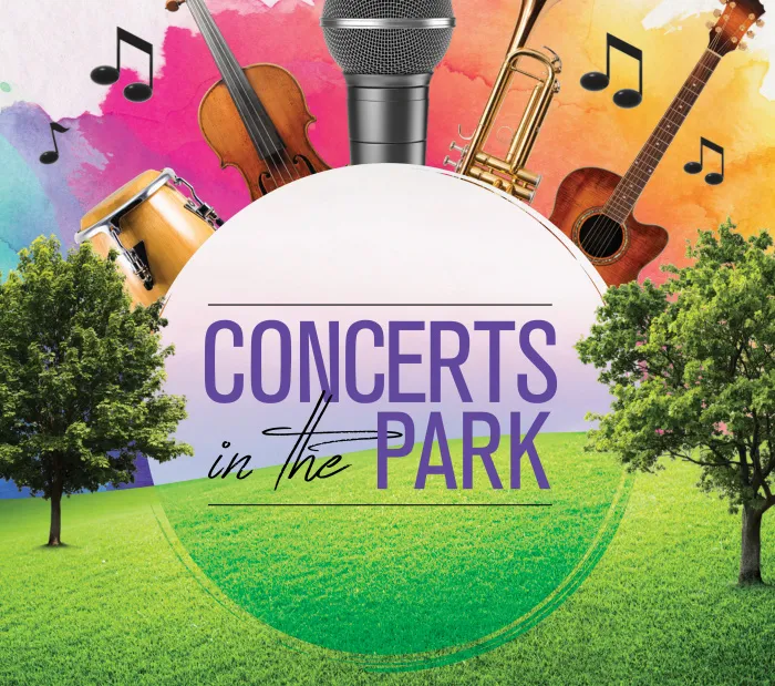 A lively outdoor concert in a park with people enjoying music and dancing under the trees.