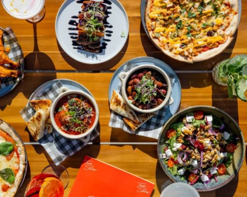 A table filled with a variety of dishes, including fruits, vegetables, meats, and desserts, showcasing a colorful spread.