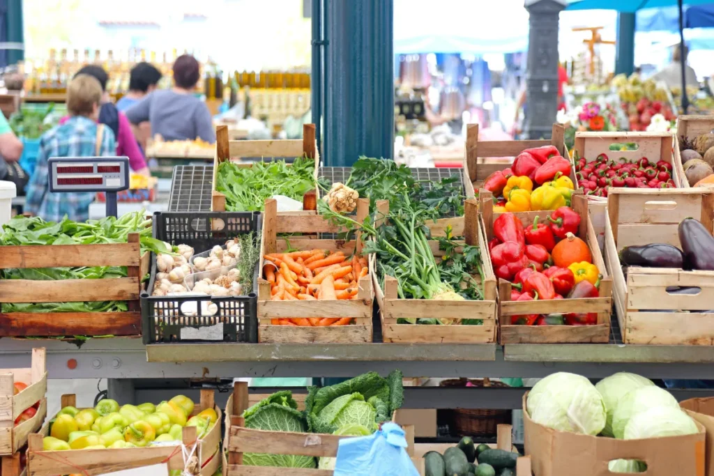 A vibrant market stall filled with a variety of fresh vegetables and fruits in colorful displays.
