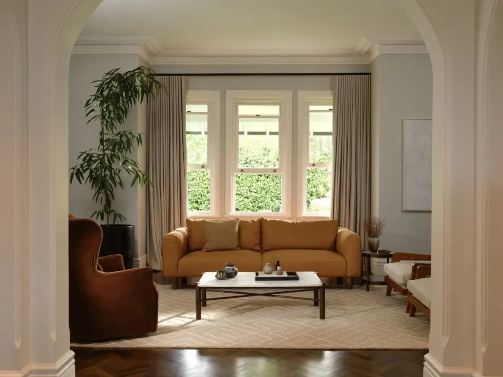 A bright living room with a comfortable couch, a coffee table, and a window showcasing outdoor views.