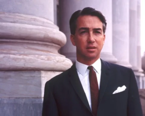 Don Dunstan in a suit and tie stands confidently in front of tall, classical pillars.