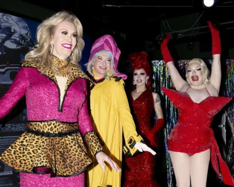 A group of women dressed in colorful costumes and elaborate makeup, smiling and posing together for the camera.