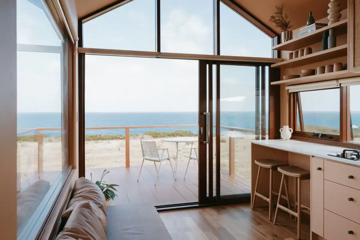 A cozy tiny house featuring a compact kitchen and a welcoming living room area.