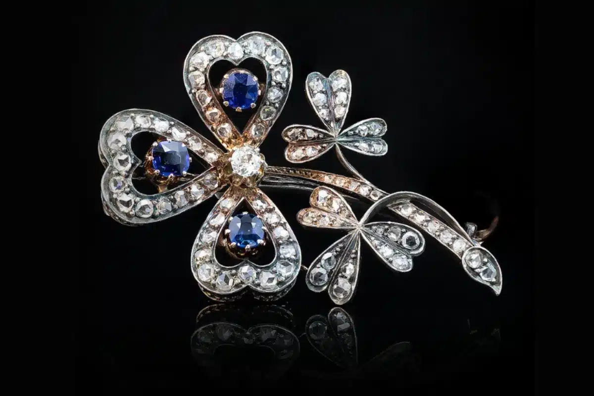 Antique brooch featuring intricate designs adorned with sapphires and diamonds.