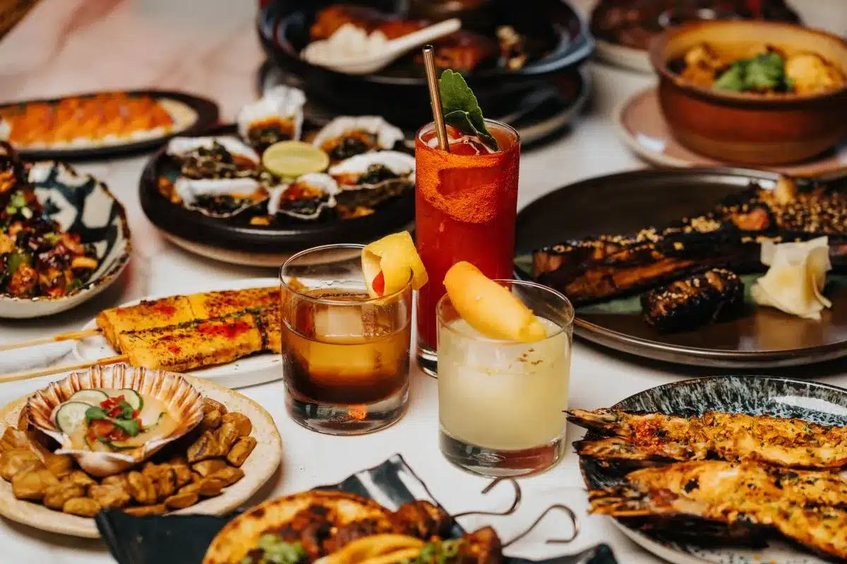 A table filled with a variety of colorful dishes, including fruits, vegetables, and assorted main courses.
