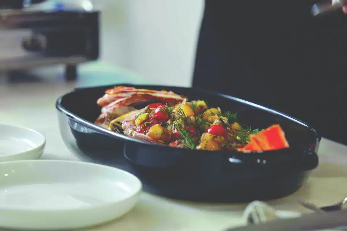 A person holds a knife in one hand and a fork in the other, preparing to eat a meal.