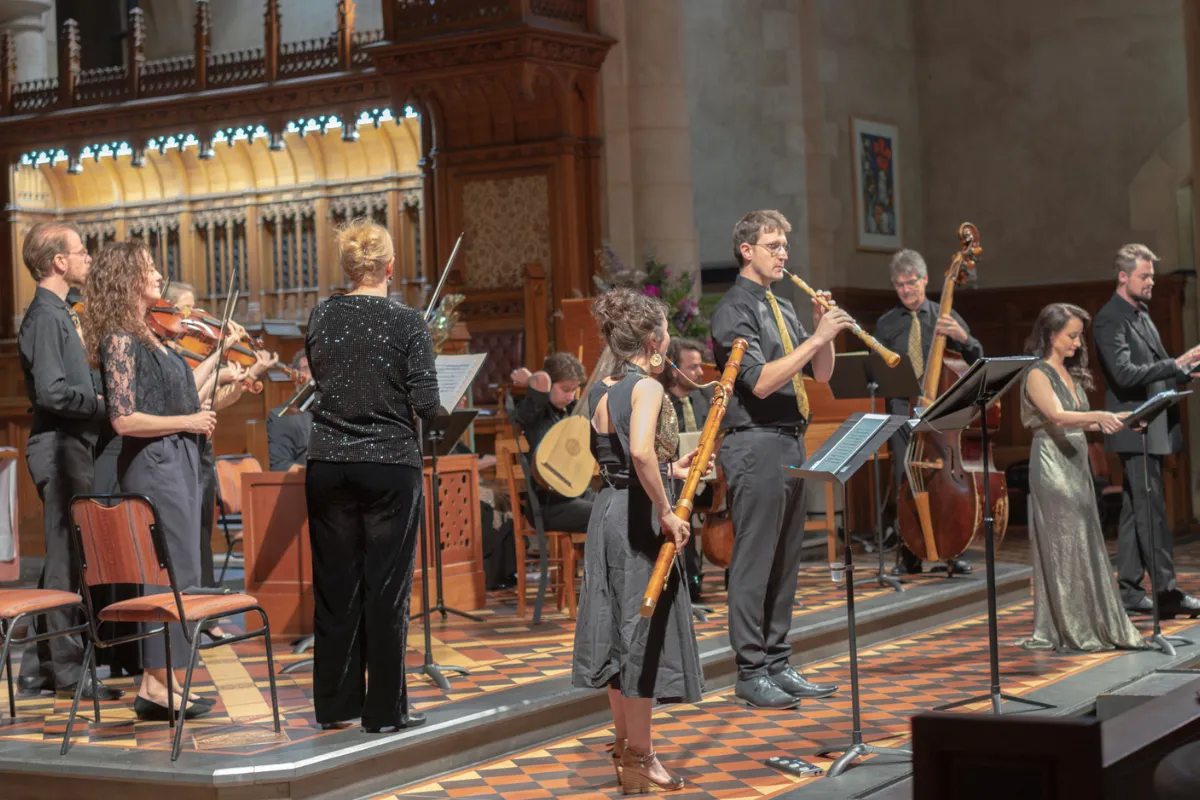 A group of musicians playing various instruments inside a church, creating a lively and harmonious atmosphere.