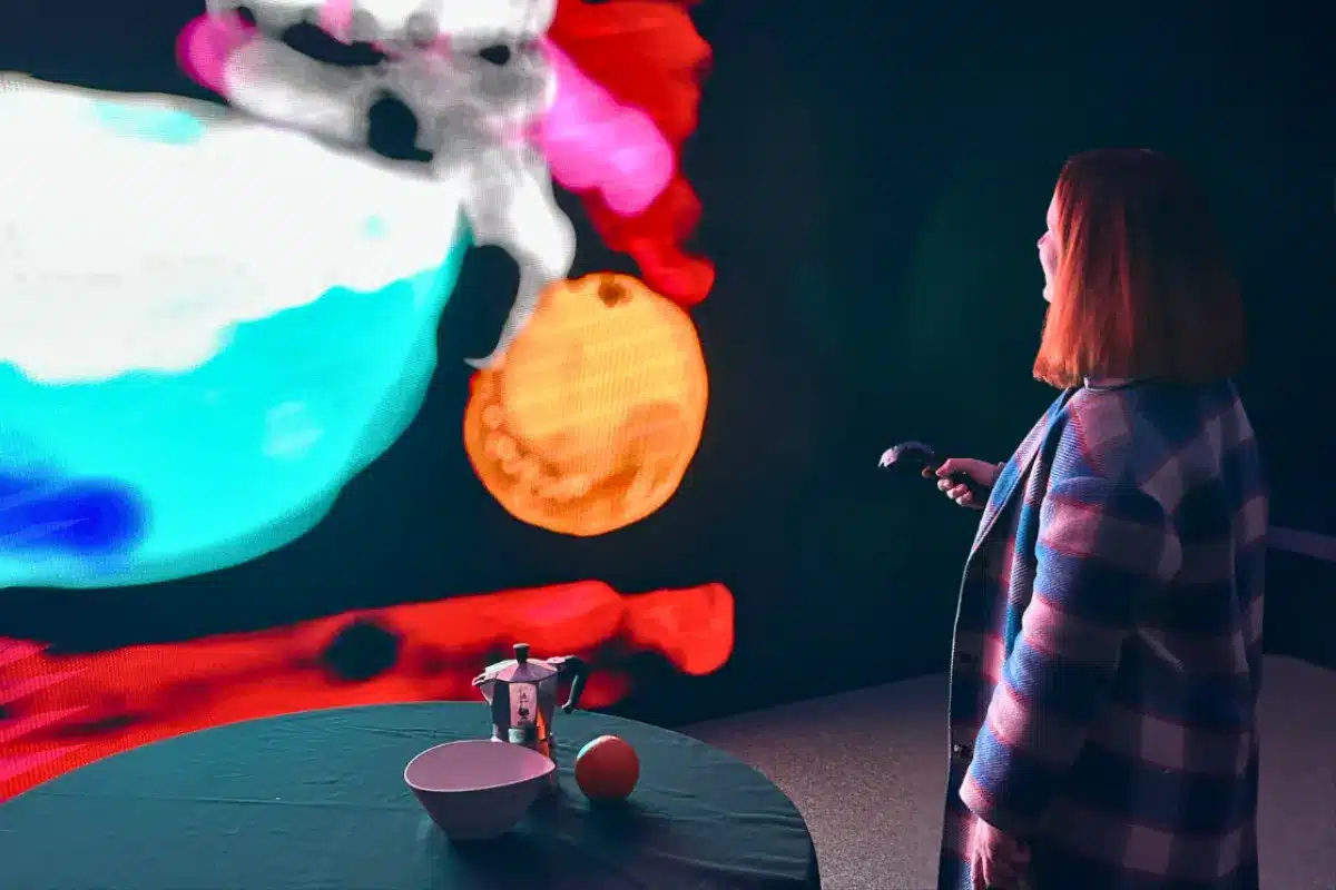 A woman uses a laser to paint on a screen.