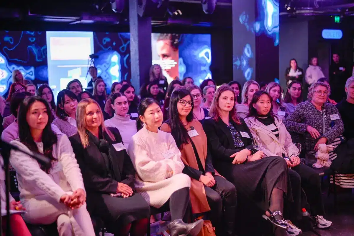 A group of women seated in chairs, engaged in discussion at a professional conference.