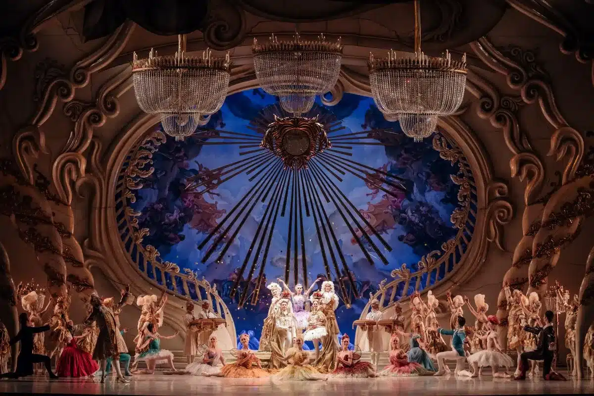 The Sleeping Beauty production featuring dancers in festive costumes on a beautifully lit stage.