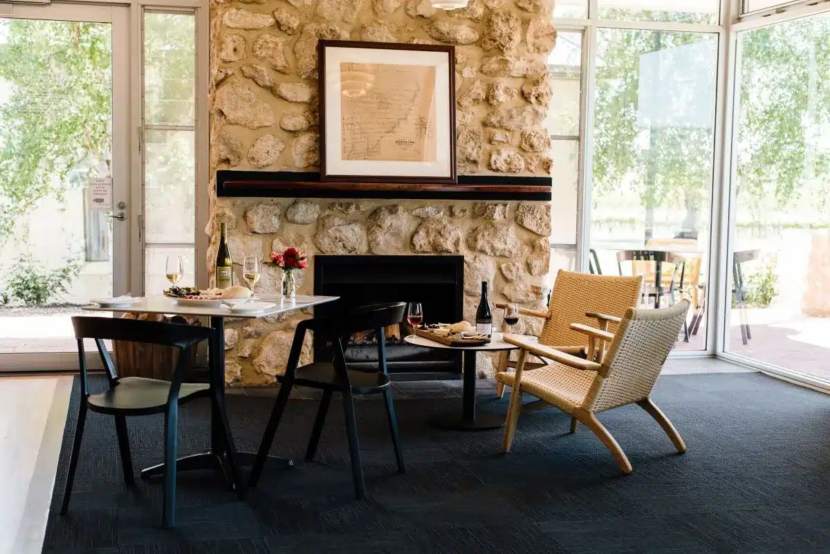 A cozy dining area featuring a fireplace and a wooden table, creating a warm and inviting atmosphere.