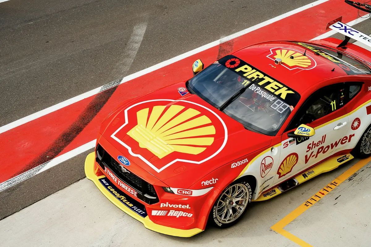 A sleek shell race car speeding down the track, showcasing its vibrant colors and aerodynamic design.