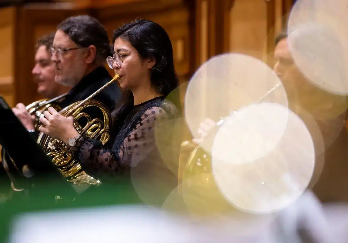 A woman playing the French horn.