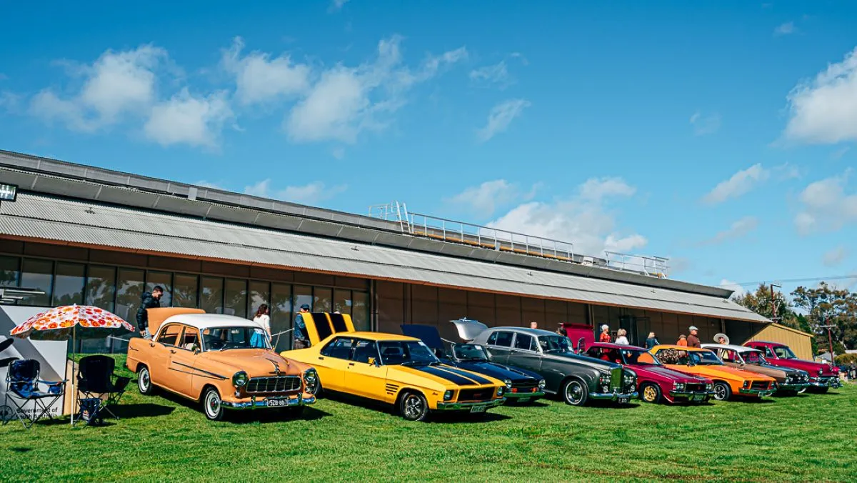 A row of parked cars in front of a building, showcasing a mix of colors and styles.