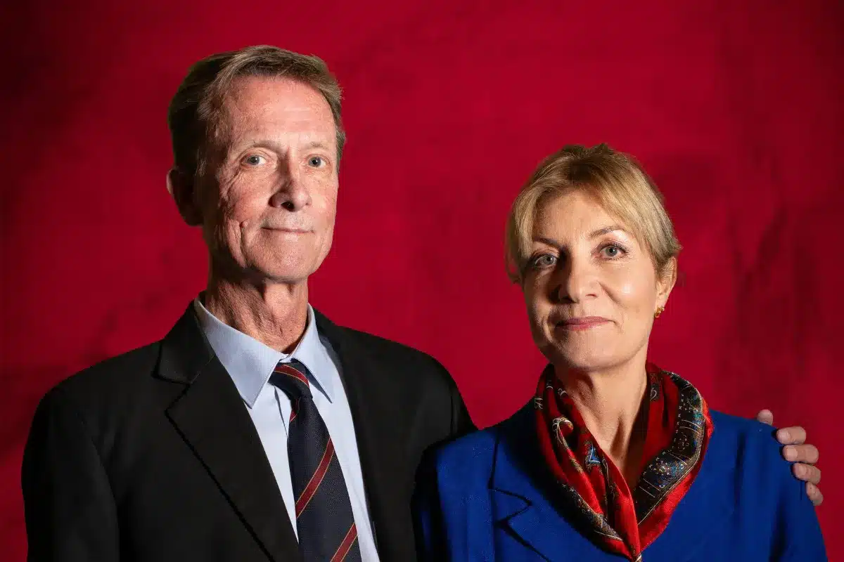 A man and woman standing together, smiling at the camera