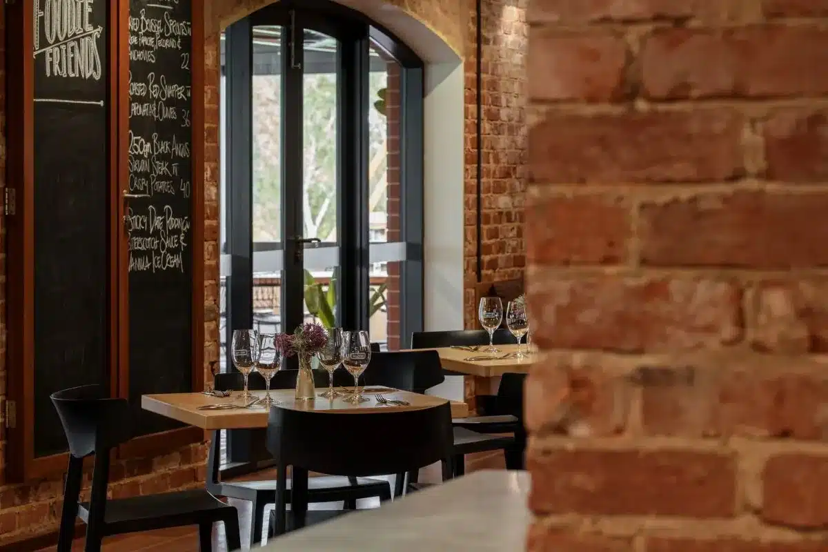 A cozy restaurant featuring exposed brick walls and a chalkboard menu displaying daily specials.