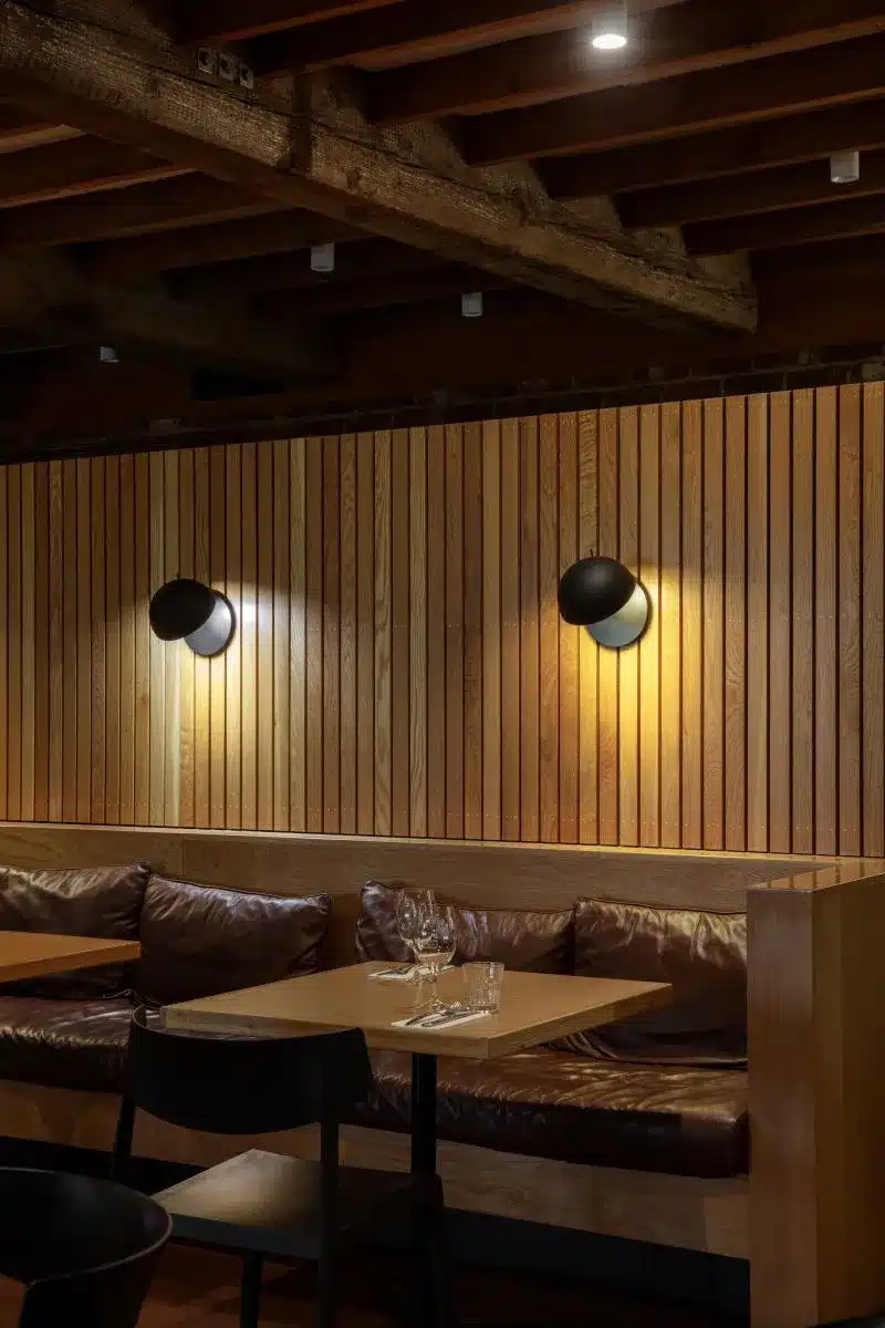 A cozy restaurant featuring wooden walls and booths, creating a warm and inviting atmosphere for diners.