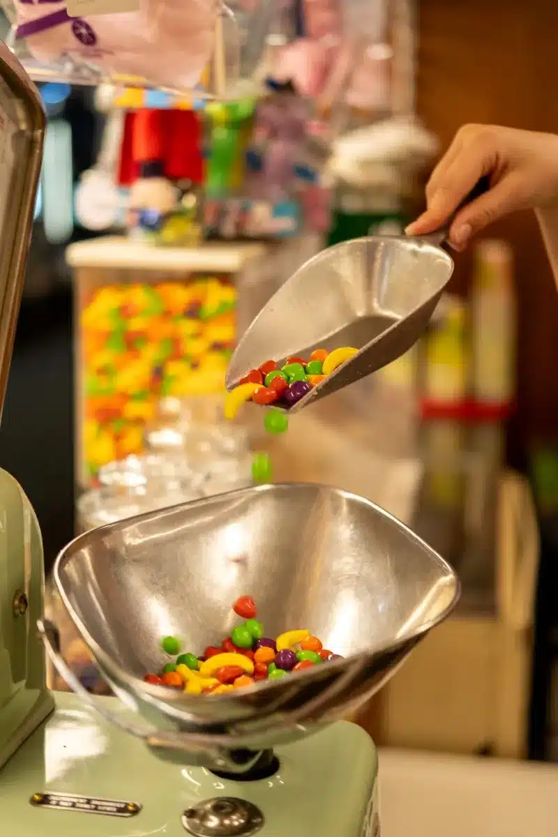 Lollies being poured onto scales.
