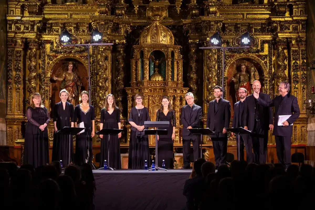 A choir performs on stage, showcasing their vocal talents in front of an audience.