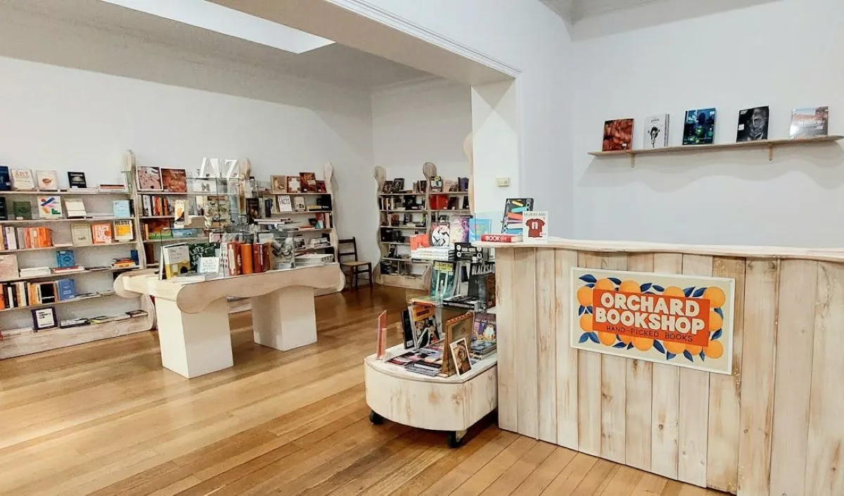 A cozy bookstore featuring a wooden counter and filled shelves lined with various books.