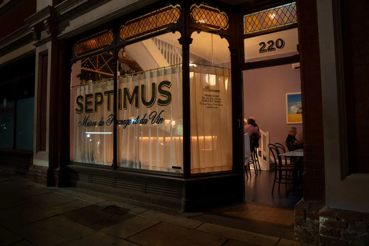 A restaurant exterior featuring a prominent sign that reads "Septimus," inviting patrons to enter.