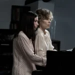 Two women playing a grand piano together in a cozy room filled with warm light and musical notes.