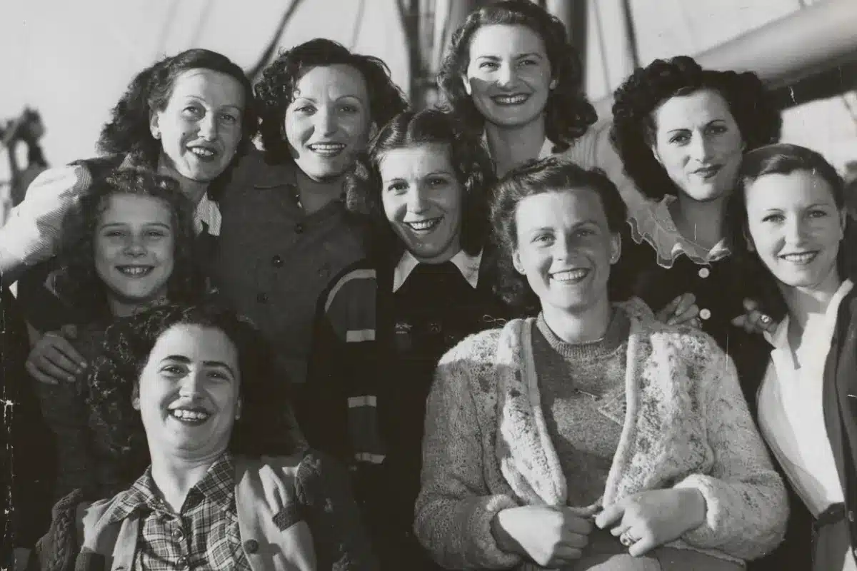 A group of women smiling and posing together for a photo outdoors.