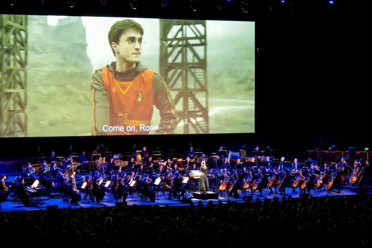A large screen displays a scene from a Harry Potter movie, showcasing magical elements and characters.