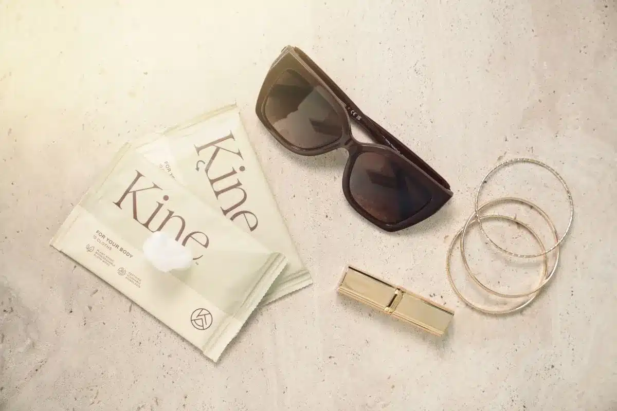 Sunglasses, wipes and a lipstick on a table.