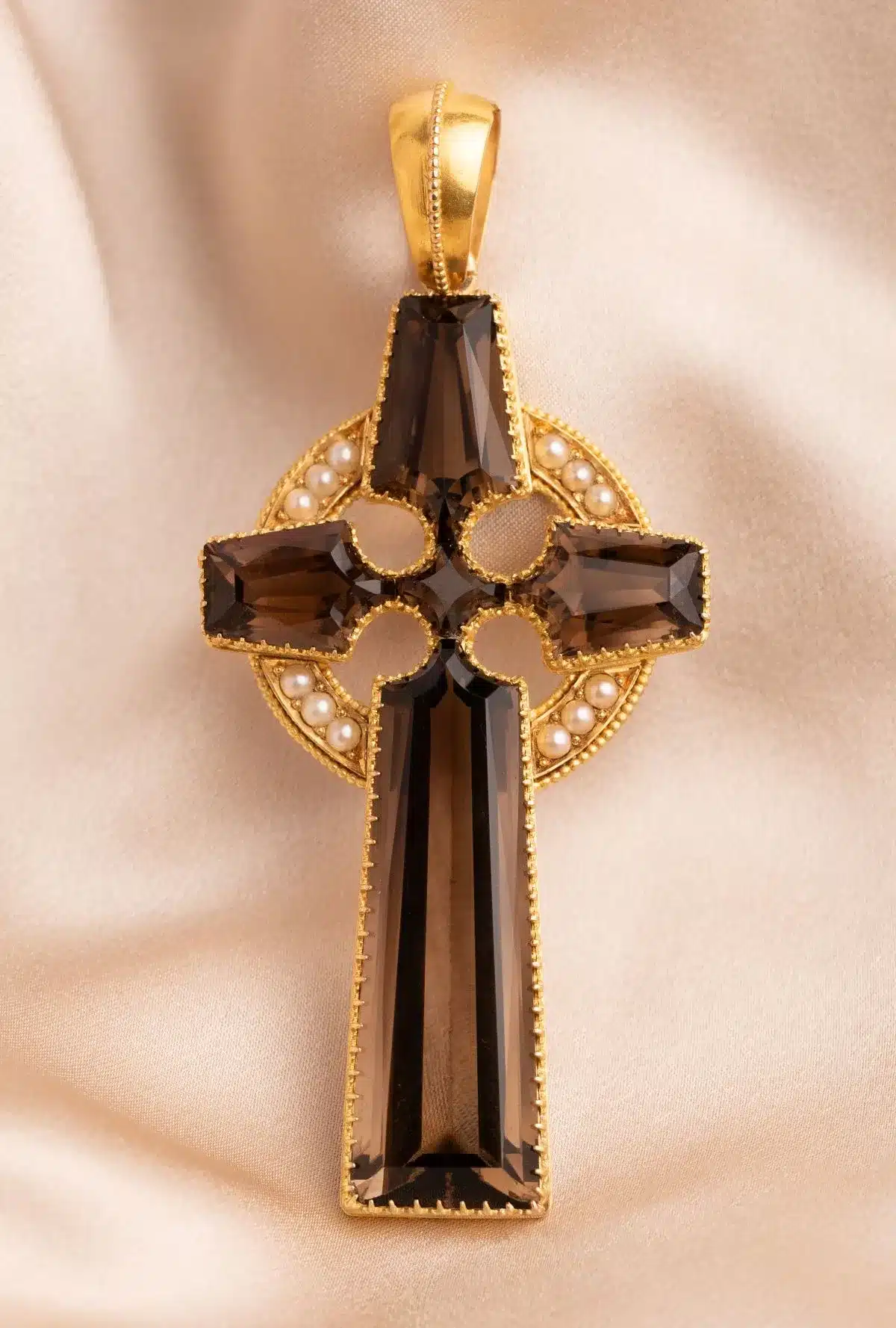 A gold cross pendant featuring a brown crystal stone at its center, elegantly designed for a classic look.