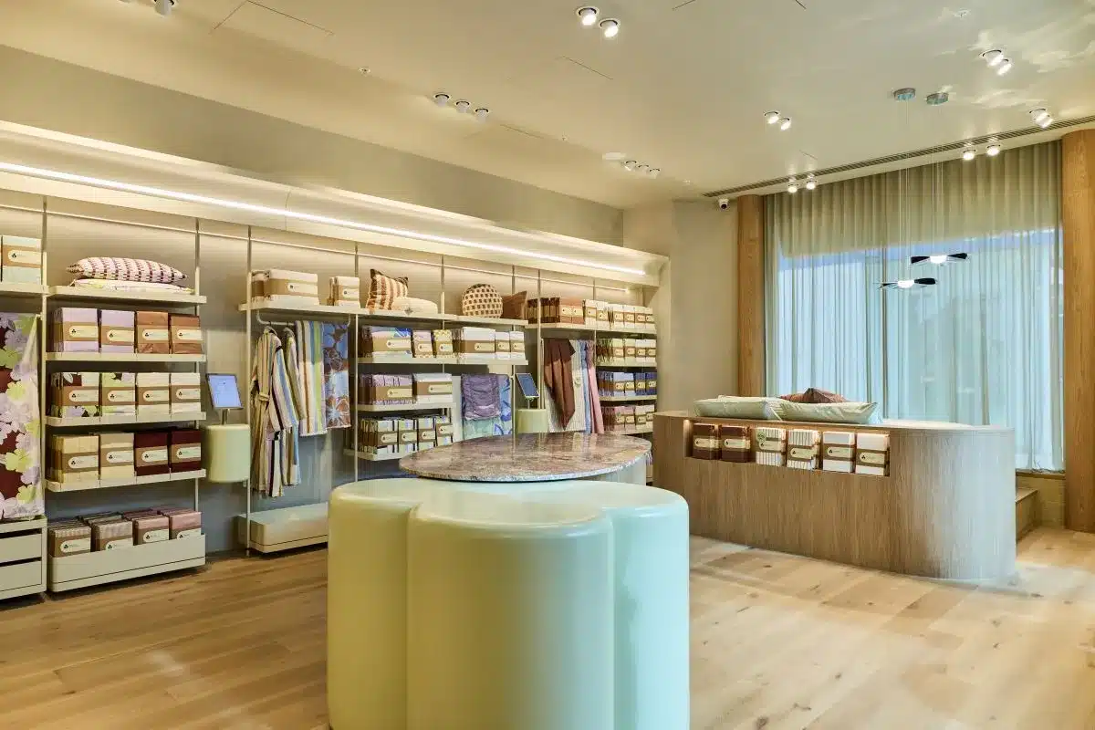 A store interior featuring shelves stocked with products and a counter at the front for customer service.