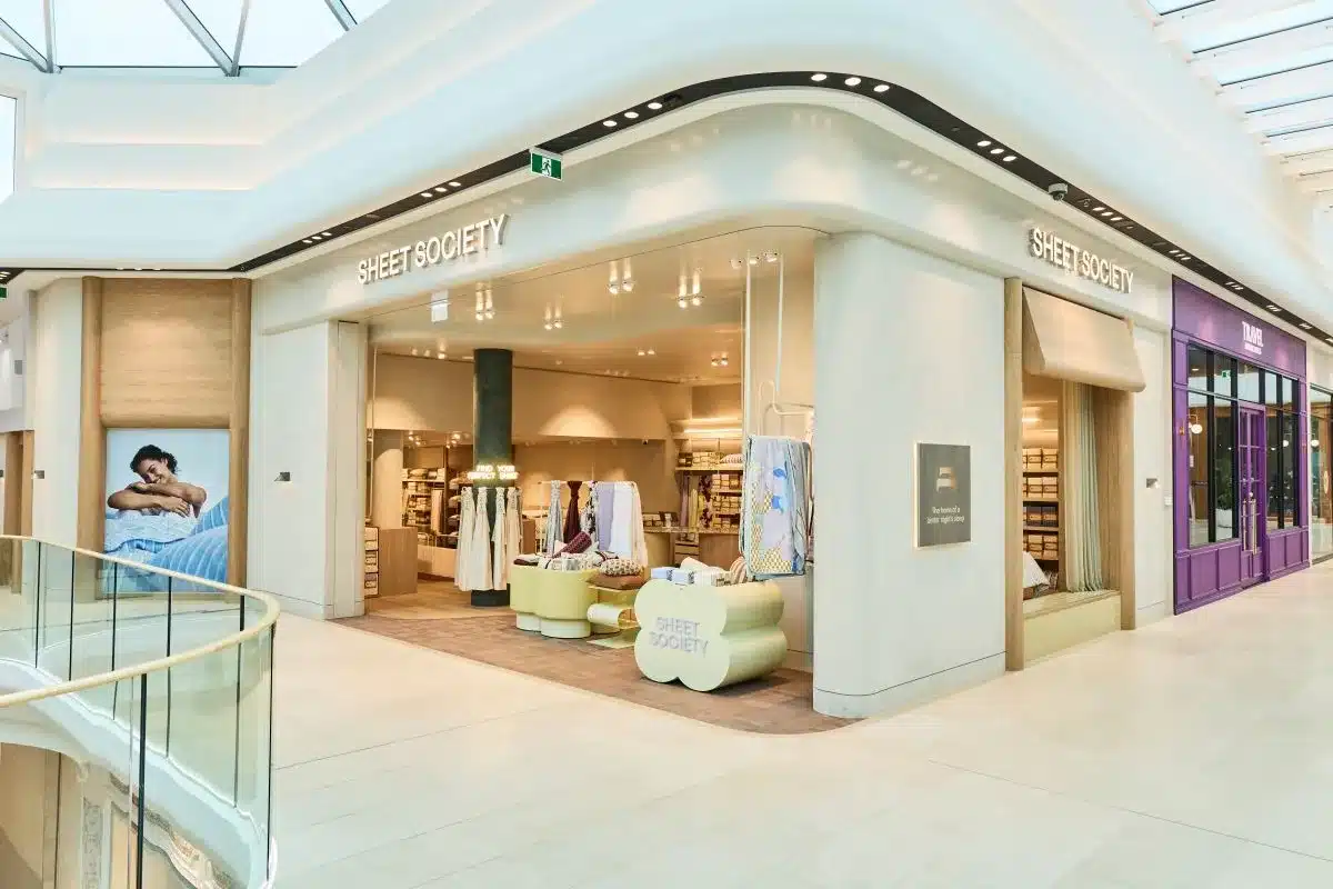 A spacious store featuring a glass ceiling and a large window, allowing natural light to illuminate the interior.
