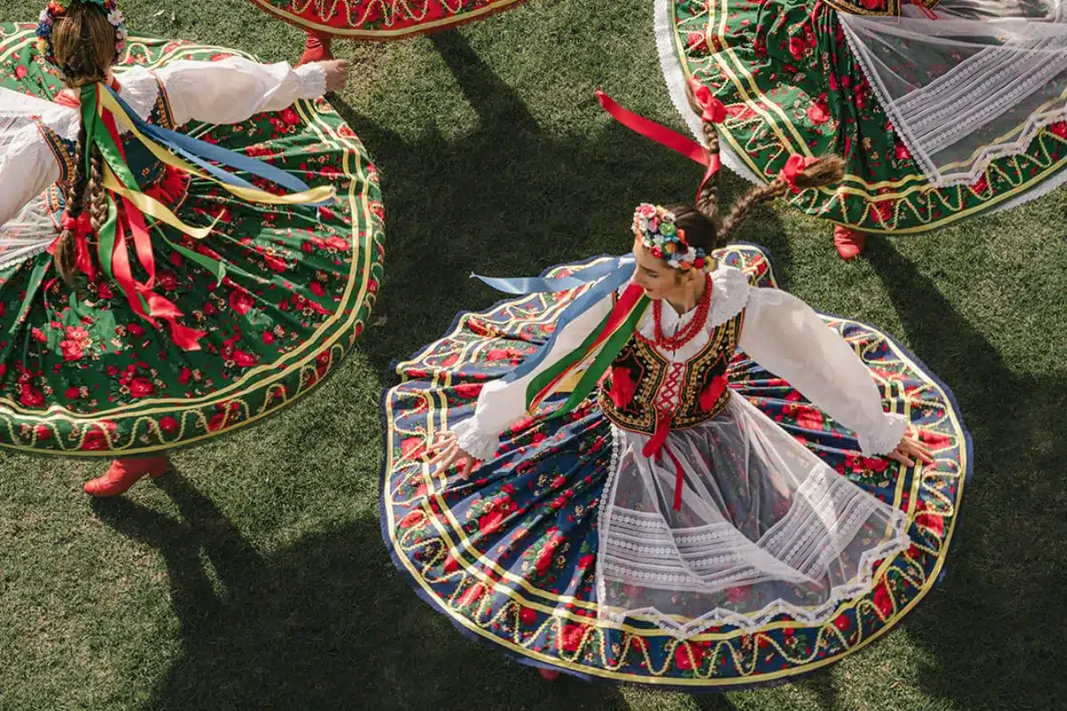 A group of women in colorful traditional costumes joyfully dancing together in a lively celebration.