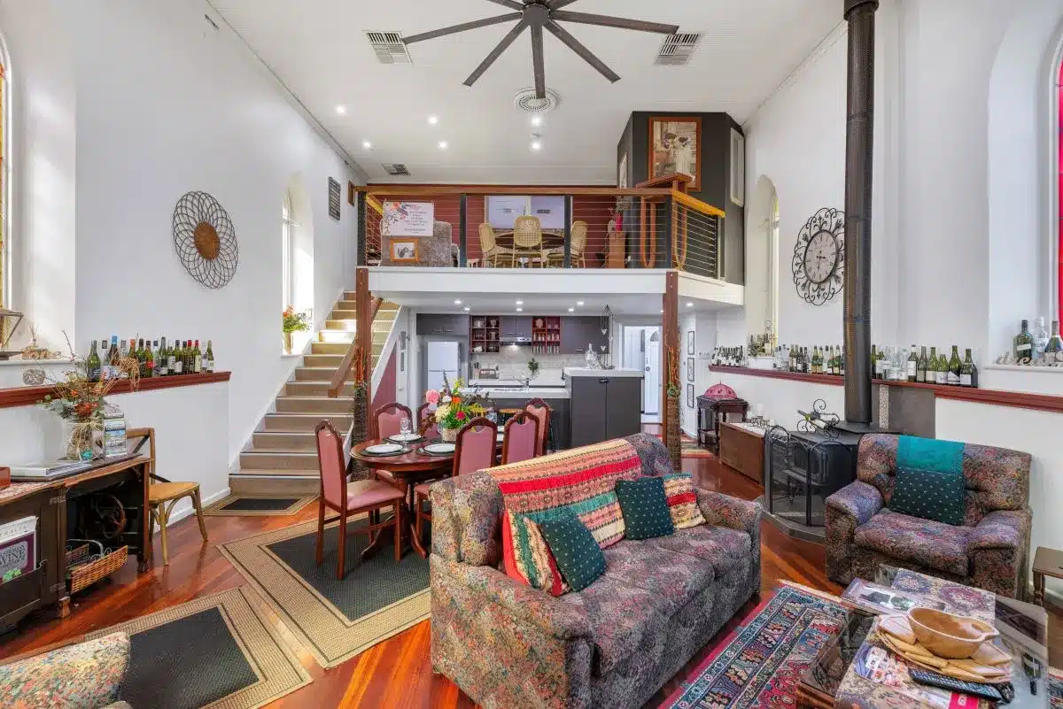 A spacious living room featuring a staircase and a large window that lets in natural light.