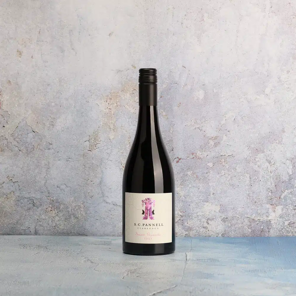 A bottle of wine featuring a pink label, elegantly displayed against a neutral background.