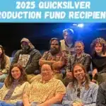 A group of people seated in a theater, attentively posing for a photo together.