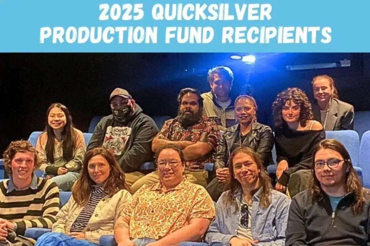 A group of people seated in a theater, attentively posing for a photo together.