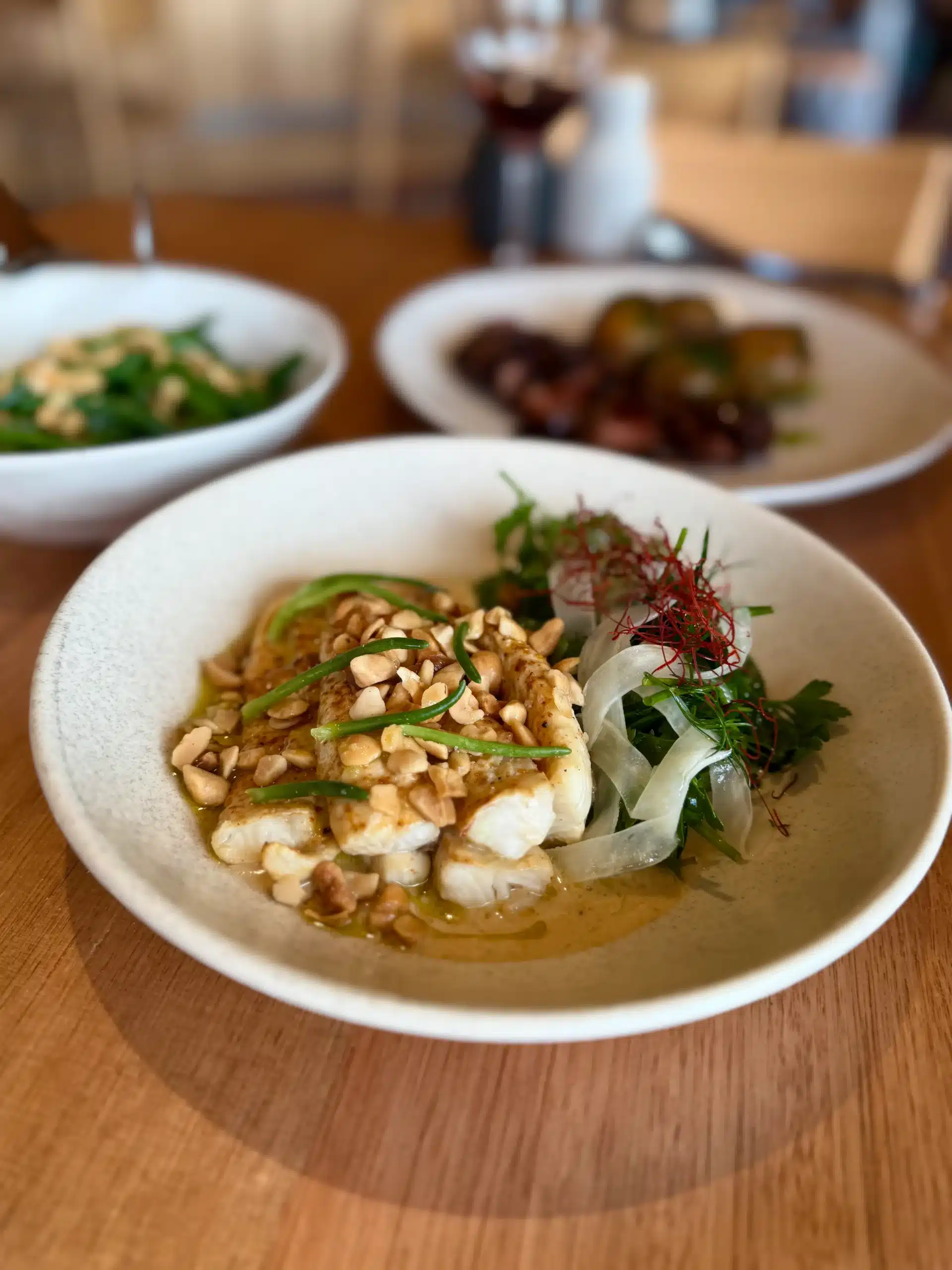 A modern plate of assorted small bites and charcuterie-style items arranged on a speckled ceramic dish.