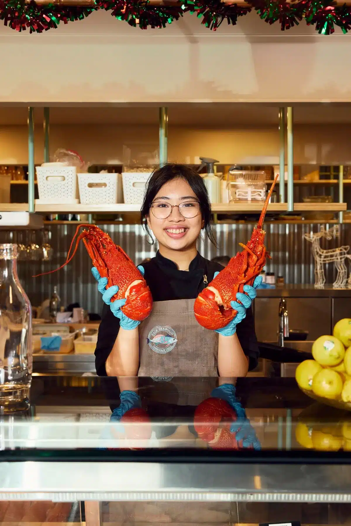Girl holds up lobsters.
