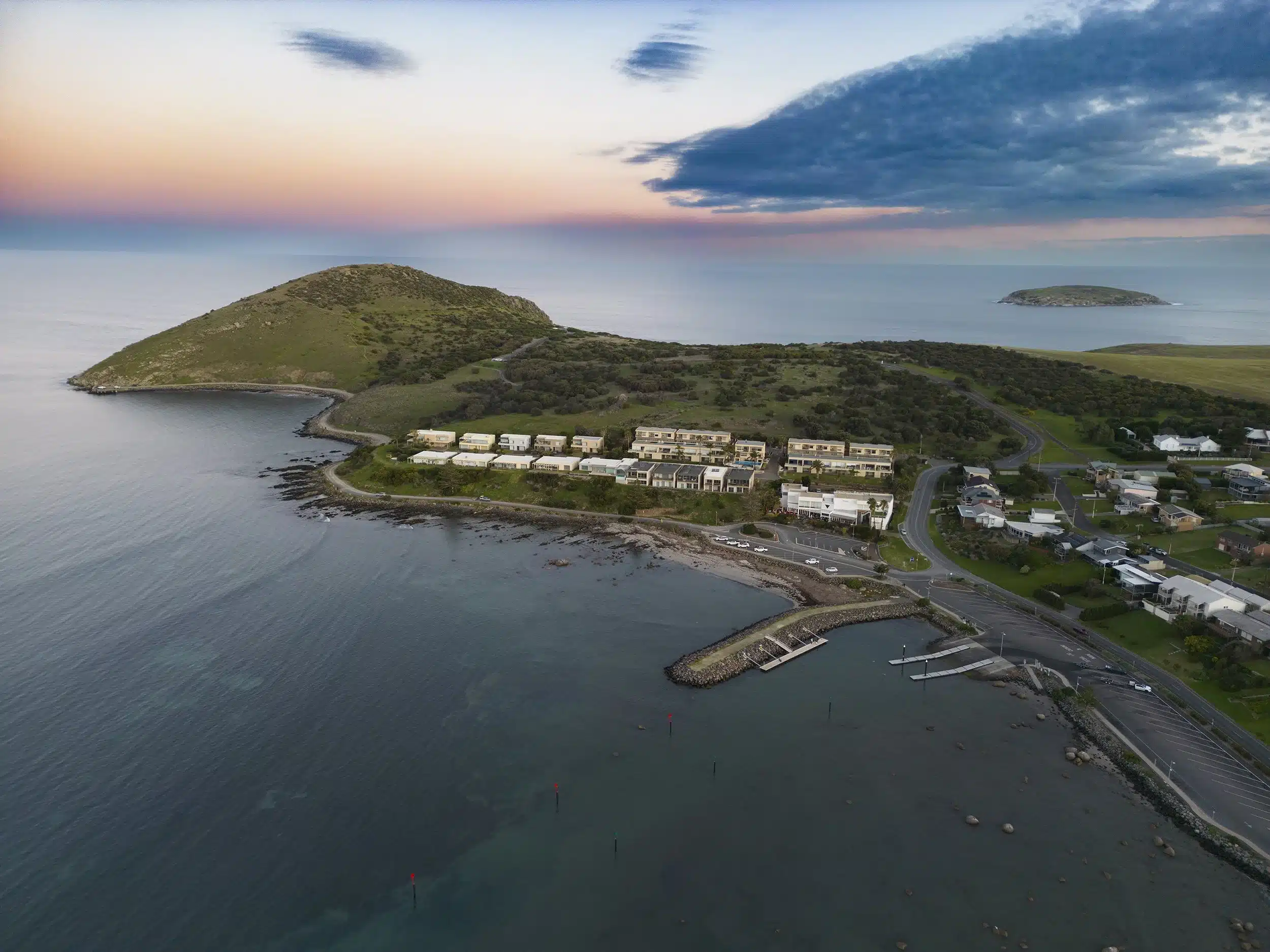 Aerial view of the ocean with waves and coastal buildings, showcasing the vibrant shoreline and urban landscape.