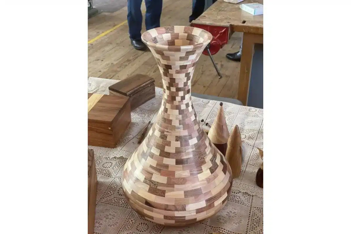 A decorative vase crafted from wood, showcasing a unique patterned design.