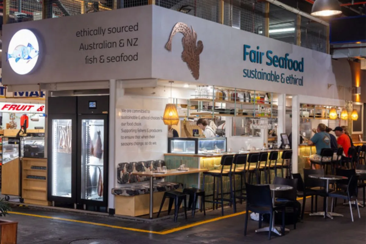 shop front of a seafood market stall with fish hanging in fridge